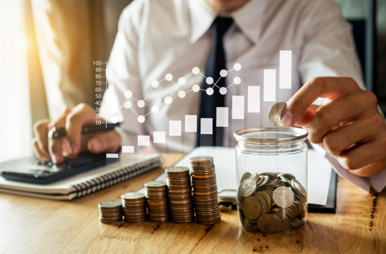 businessman holding coins putting in glass with using smartphone and calculator to calculate concept saving money for finance accounting