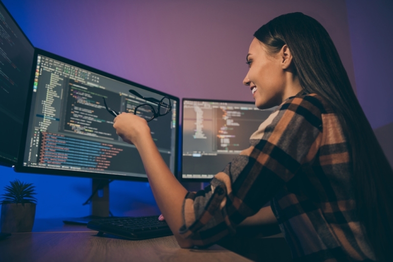 This photo shows a side profile below angled view photo of cheerful positive employee viewing screens. 